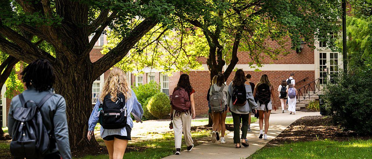 Students walking with backpacks on to a building.